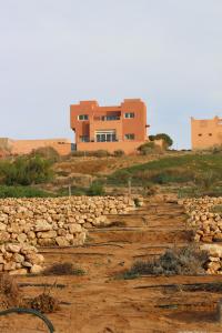 una casa en la cima de una colina con un camino de tierra en Riad Daribis vue sur la mer Agadir, en Rbat