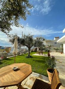 a patio with a table and an umbrella at GardenView Retreat in Ksamil