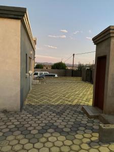 a patio with a building and a bench in a yard at Nkhahle's house in Maseru