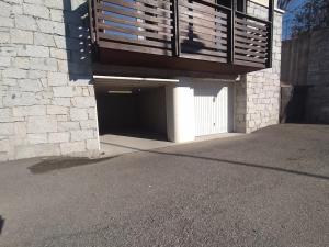 a garage under a balcony on the side of a building at Adamello Peak ONE Apartment in Temù