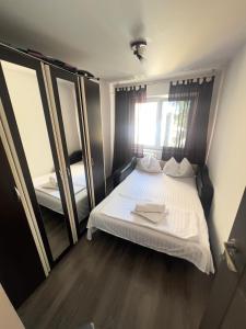 a bedroom with a white bed and a large mirror at City Charm -3 rooms with free Parking in Iaşi
