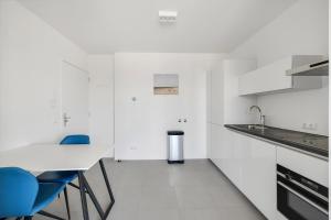 アウウドルプにあるAppartement Aloha 4P - Residence Kabbelaarsbankの白いキッチン(青い椅子、テーブル付) +18枚の写真