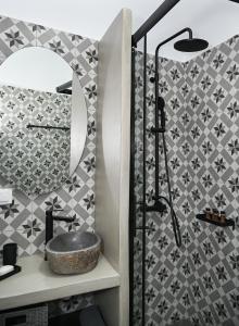 a bathroom with a sink and a mirror at The Friend's House Milos in Triovasálos