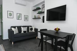 a living room with a table and a couch and a television at The Friend's House Milos in Triovasálos