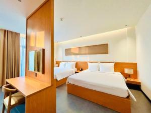 ein Hotelzimmer mit zwei Betten und einem Schreibtisch in der Unterkunft Thai Hoang Villa Quảng Bình in Dong Hoi + 55 Fotos