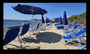 a group of chairs and umbrellas on a beach at Mis Flores,appartamento con parcheggio, parco e spiaggia privata in Santa Marinella