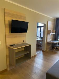 a living room with a flat screen tv on a wall at Hotel Stadthaus in Erlangen