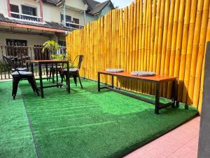 a patio with two tables and chairs and a fence at Penny Hostel & Cafe in Thong Sala