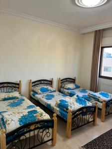 a bedroom with two beds and a window at Furnished Family Apartment in Dahyet Al-Rasheed in Amman
