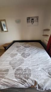 a bed with a white blanket on top of it at Appart 4 pers pied des pistes- l'Ecrin-les BERGERS- Chez Lexy in L'Alpe-d'Huez