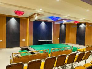 a conference room with a green table and chairs at BSR plaza in Elūru
