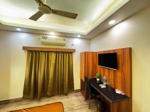 a room with a desk and a television in a room at Silver Line Hotel - Kolkata Nr Netaji Subhash Chandra Bose International Airport with Airport Drop in Kolkata