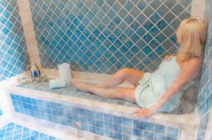 a woman is sitting in a bath tub at Chambre Meknes, Riad 7 au village naturiste Couple only in Cap d'Agde