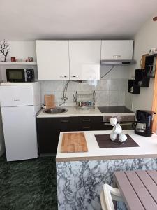 a kitchen with white cabinets and a counter top at Apartments Samaržija- new 63 not 47 in Bibinje