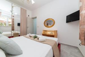 a bedroom with a white bed and a television at Dimora Cavallo a 150m da spiaggia sabbiosa in Torre Santa Sabina +30 photos