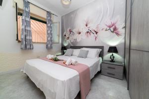 a bedroom with a bed with pink flowers on the wall at Dimora Cavallo a 150m da spiaggia sabbiosa in Torre Santa Sabina