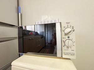 a kitchen with a microwave with the door open at 花の郷田端b02 in Tokyo +4 photos