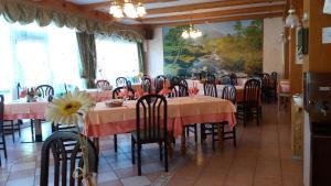 a dining room with tables and chairs and a painting at Hotel La Piroga in Calceranica al Lago