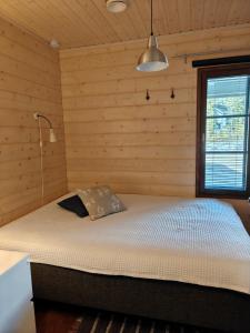 a bedroom with a bed in a wooden room at Vutnusmaja air-conditioned holiday home at Iso-Syöte in Syöte