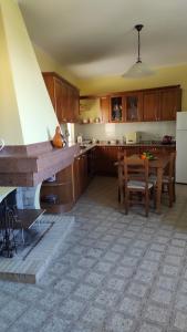 a kitchen with a table and a dining room at Cora Manna casa vacanze in Càbras