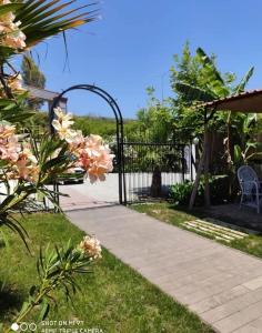 ein Garten mit einem schwarzen Tor und rosa Blumen in der Unterkunft Nostalgia World Boutique Hotel in Kızılot