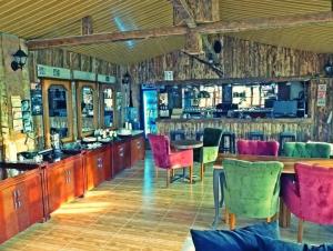 ein Restaurant mit einer Bar mit rosa und grünen Stühlen in der Unterkunft Nostalgia World Boutique Hotel in Kızılot