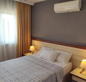 ein Schlafzimmer mit einem Bett, zwei Lampen und einem Fenster in der Unterkunft Nostalgia World Boutique Hotel in Kızılot