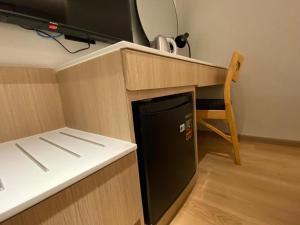 a kitchen with a black dishwasher under a counter at 32E Home Sleep Home in Kuah