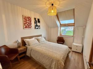 a bedroom with a bed and a lamp and a window at Ático Son do Mar by Cristian&Tamara "alquileres" in Porto do Son
