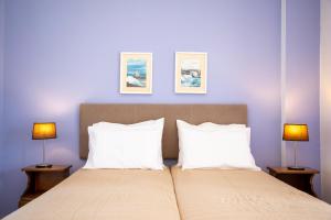 a bedroom with a large bed with two lamps at Stefanie Studios in Egina