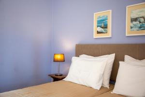 a bedroom with a bed with white pillows and a lamp at Stefanie Studios in Egina