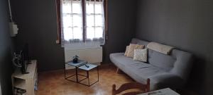 a living room with a couch and a window at Petite maison ploufragan in Ploufragan