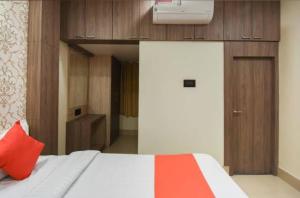 a bedroom with a bed with a red pillow at Hotel Eden Park in Nimtita