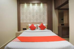 a bedroom with a large bed with red pillows at Hotel Eden Park in Nimtita