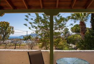 a table and chairs on a balcony with a view of the ocean at Stefanie Studios in Egina