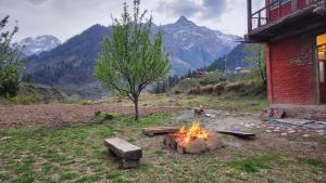 eine Feuerstelle in einem Feld neben einem Gebäude in der Unterkunft MJ cafe and homestay in Jāmb