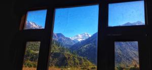 einen Blick auf eine Bergkette aus dem Fenster in der Unterkunft MJ cafe and homestay in Jāmb + 6 Fotos