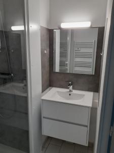 ein weißes Badezimmer mit Waschbecken und Dusche in der Unterkunft Home cavalaire in Cavalaire-sur-Mer + 8 Fotos