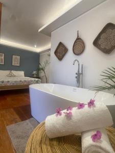 a bathroom with a tub and a bed at Apoheo Beach Cabin Free Use Motrbike Drng Stay in El Nido