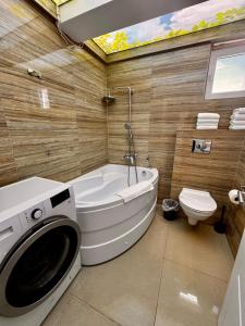 a bathroom with a tub and a washing machine in it at RoApart B2 Home Apartamente 2 și 3 camere terase spațioase vedere si parcare in Năvodari