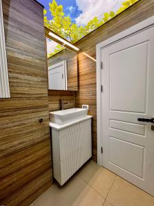 a bathroom with a white sink next to a door at RoApart B2 Home Apartamente 2 și 3 camere terase spațioase vedere si parcare in Năvodari +37 photos