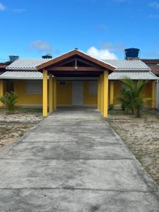 ein gelbes Haus mit einer Auffahrt davor in der Unterkunft Recanto do Rey in Mucuri