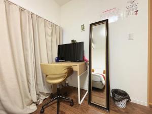 a room with a desk with a computer and a mirror at 花の郷田端b04 in Tokyo
