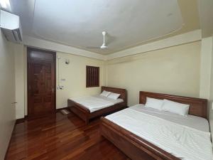een slaapkamer met 2 bedden en een deur bij Phương Huyền Beauty in Diện Biên Phủ