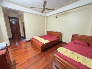 een slaapkamer met twee bedden en een plafondventilator bij Phương Huyền Beauty in Diện Biên Phủ