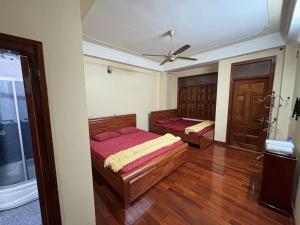 een slaapkamer met twee bedden en een plafondventilator bij Phương Huyền Beauty in Diện Biên Phủ