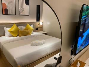 a bedroom with a bed and a flat screen tv at 32F Home Sleep Home in Kuah