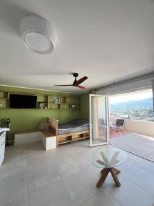 アジャクシオにあるCœur Ajaccio calme plage natureのリビングルーム(ベッド1台、天井ファン付)