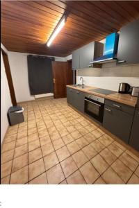 a kitchen with a tiled floor with a stove top oven at Rösrath Wohnung mit Küche in Rösrath