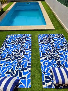 a swimming pool with a blue and white patterned rug at Meco Beach and Private Pool Villa in Sesimbra
